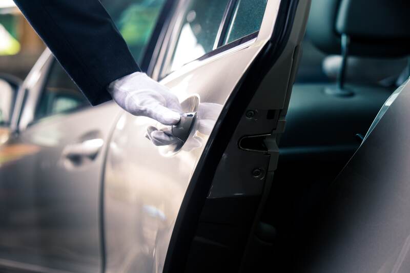 private driver opening door with gloved hand